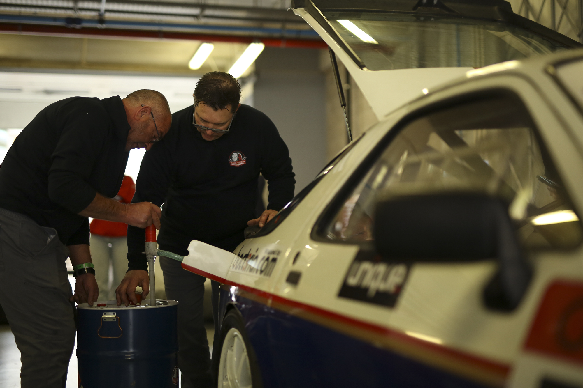 dois mecanicos a por gasolina num carro